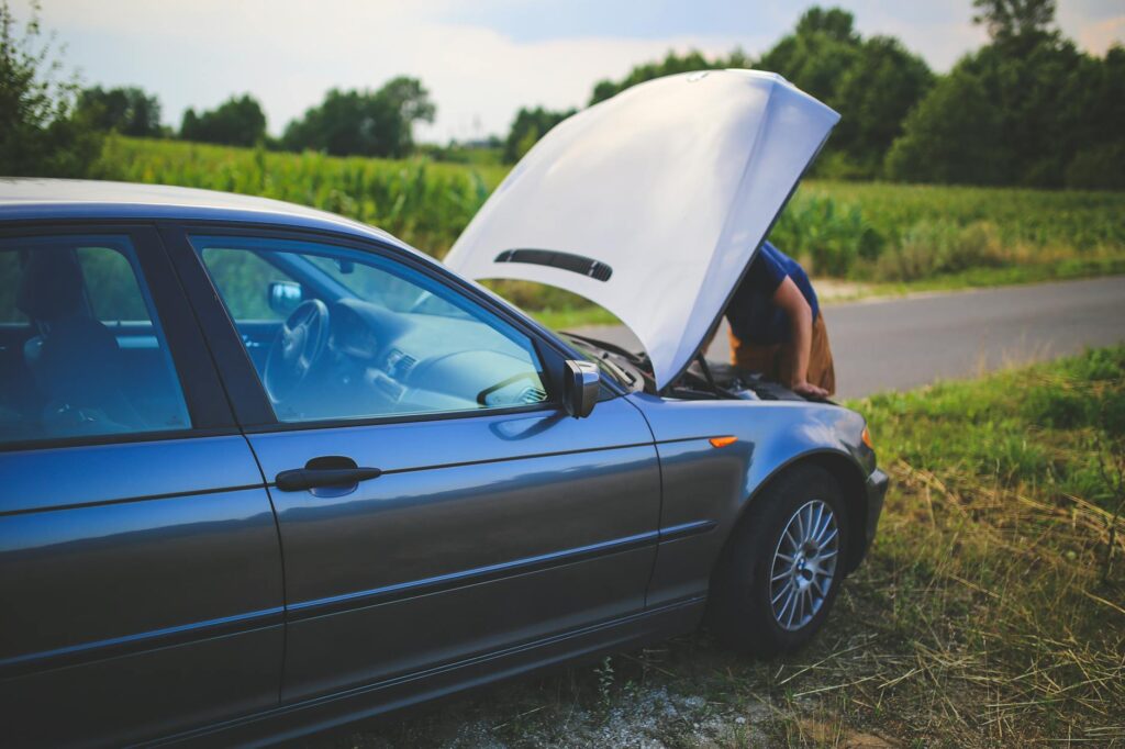 A close-up of a driver assessing the vehicle engine during a breakdown. — car breakdown las vegas