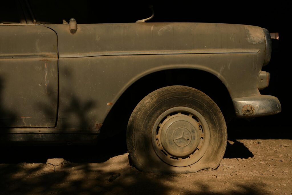 A close-up of a flat tire on a car parked on the side of the road. — common reasons for towing Las Vegas