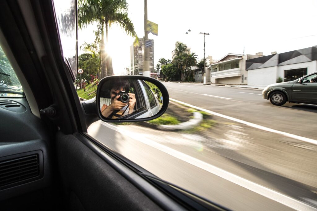 An image showing a driver taking photos of their vehicle for documentation purposes. — vehicle breakdown documentation