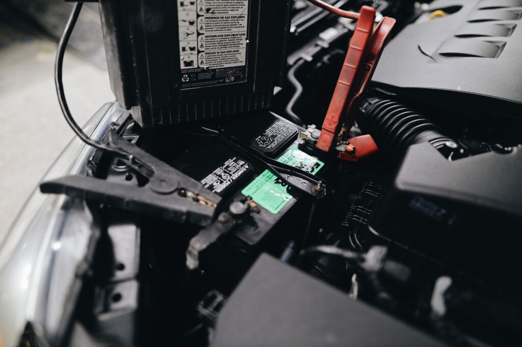 Close-up of jumper cables connected to a car battery. — dead battery assistance