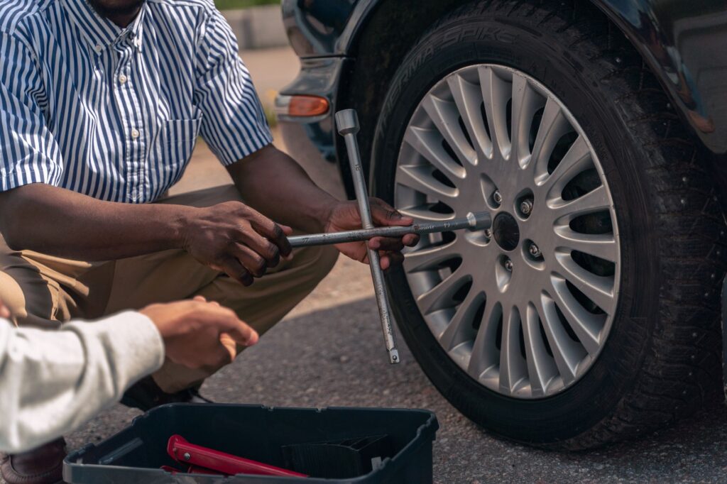 Image of a driver practicing changing a tire, demonstrating how to use roadside supplies effectively. — roadside checkli…